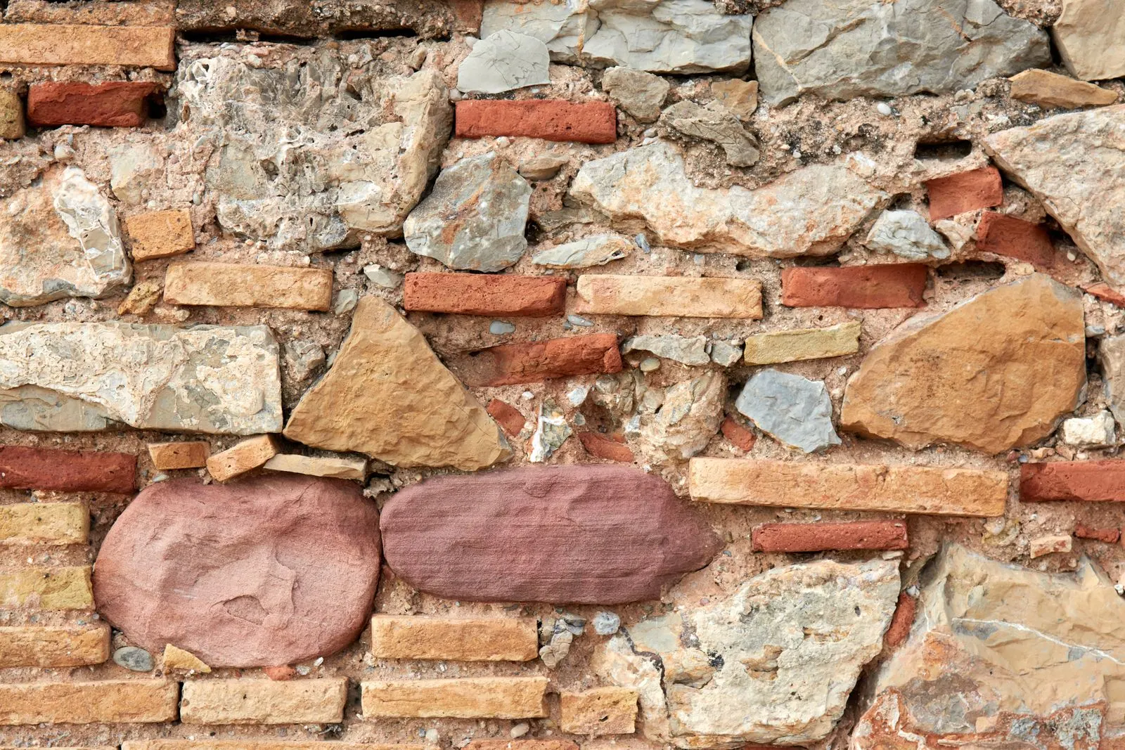 Textured stone and brick masonry wall